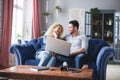 Happy couple using laptop on sofa at home Royalty Free Stock Photo