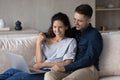 Happy couple using laptop together, relaxing on couch Royalty Free Stock Photo