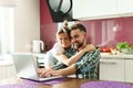 Happy couple using laptop for videocall in the kitchen at morning Royalty Free Stock Photo