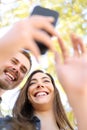 Happy couple using smart phone together in a park Royalty Free Stock Photo
