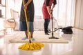 Couple clean bedroom by mop, vacuum cleaner