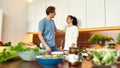 Happy couple, vegetarians looking at each other while going to prepare healthy meal, sandwhich, salad in the kitchen Royalty Free Stock Photo