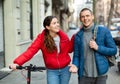 Couple are walking along the spring street. Girl with electric scooter Royalty Free Stock Photo