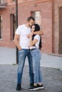 Happy couple walking in the centre of the city. Handsome man and attractive woman in white shits Royalty Free Stock Photo