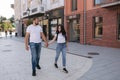 Happy couple walking in the centre of the city. Handsome man and attractive woman in white shits Royalty Free Stock Photo