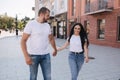 Happy couple walking in the centre of the city. Handsome man and attractive woman in white shits Royalty Free Stock Photo