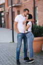 Happy couple walking in the centre of the city. Handsome man and attractive woman in white shits Royalty Free Stock Photo