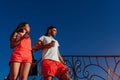 Happy couple walking in the city at sunset. Young man and woman drinking coffee and walking down the stairs Royalty Free Stock Photo