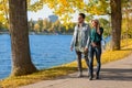 Happy couple walking in a park by the water in autumn