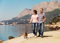 Happy couple walking with puppy on the seacoast Royalty Free Stock Photo