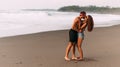 A happy couple walks along a sandy beach on the island of Bali. Couple in love at sunset by the sea. Couple in love on vacation. Royalty Free Stock Photo