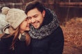 Happy couple in warm hat and scarf walking outdoor in autumn forest, cozy mood Royalty Free Stock Photo