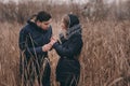 Happy couple in warm knitted hat and scarf walking outdoor in autumn forest Royalty Free Stock Photo