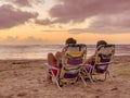 Happy couple watching enjoy luxury sunset on the beach during summer vacations. beautiful sky day Royalty Free Stock Photo