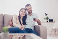 Happy couple is watching movie at home, hugging. They sit on sofa in nice livingroom Royalty Free Stock Photo