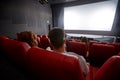 Happy couple watching movie in theater or cinema