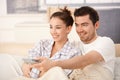 Happy couple watching television in bed Royalty Free Stock Photo