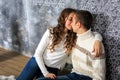 Happy couple of young people in love are sitting on the floor. Close-up Royalty Free Stock Photo