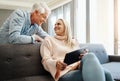 Happy couples share everything. a mature couple using a digital tablet on the sofa at home. Royalty Free Stock Photo