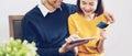 Happy couples using tablet and credit card with shopping online together at home.