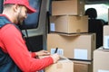 Happy courier man signing package delivery in van truck - Focus on face Royalty Free Stock Photo