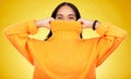 Happy, cover and portrait of a woman with a jersey isolated on a yellow background in a studio. Hiding, winter and a Royalty Free Stock Photo