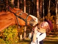 Happy cowgirl with her red horse. Royalty Free Stock Photo