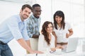 Happy coworkers working together with laptop Royalty Free Stock Photo