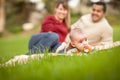 Happy Crawling Baby Boy and Mixed Race Parents Playing in the Park Royalty Free Stock Photo