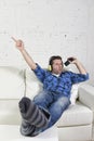 Happy crazy man on couch listening to music holding mobile phone as microphone Royalty Free Stock Photo