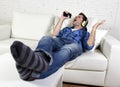 Happy crazy man on couch listening to music holding mobile phone as microphone Royalty Free Stock Photo
