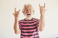 Happy and crazy senior old man with rock`n roll hand sign - alternative mature caucasian portait people have fun -youthful retire