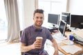 Happy creative male office worker drinking coffee