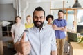 Happy creative team showing thumbs up in office Royalty Free Stock Photo