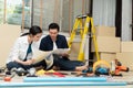 Happy creative young Asian couple renovating house together and using a blueprint for renovation planning and how to   decorate Royalty Free Stock Photo