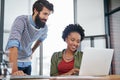 Happy creatives, laptop and team with discussion for design, planning or meeting at office. Man and woman working on Royalty Free Stock Photo