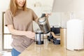 Happy cropped young woman making coffee in kitchen - french press coffee. Caucasian female model in her twenties at Royalty Free Stock Photo