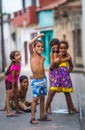 Happy Cuban children capture portrait in poor colorful colonial alley with optimistic life style, in old Habana, Cuba, America.