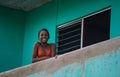 Happy Cuban girl portrait in poor colorful colonial street alley with smile and friendly face, in old Havana, Cuba, America.