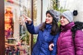 Happy curious buyers. Cheerful women looking at the shop window store Royalty Free Stock Photo