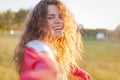 Happy curly charming girl with long curly hair and a very beautiful smile, summer portrait