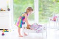 Happy curly toddler girl playing with her teddy bear Royalty Free Stock Photo