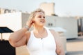 Happy curvy woman standing on a roof. Young oversized female taking a break