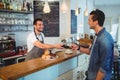 Happy customer paying through credit card at coffee shop Royalty Free Stock Photo