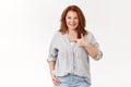 Happy customer recommends service. Attractive satisfied middle-aged elegant redhead lady show thumb up approval gesture