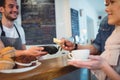 Happy customers and barista at coffee shop