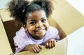 Happy cute active little african american kids girl play riding in cardboard boxes feel excited to move in new house