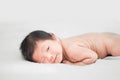 Happy cute adorable Asian baby boy with black hair lying on a white bed. Royalty Free Stock Photo