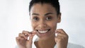 Happy cute African American girl flossing white teeth Royalty Free Stock Photo