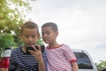 Happy cute Asian boy play game with smartphone sit on the park Royalty Free Stock Photo